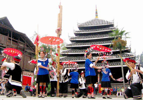Dong people is celebrating their festival by a drum tower.