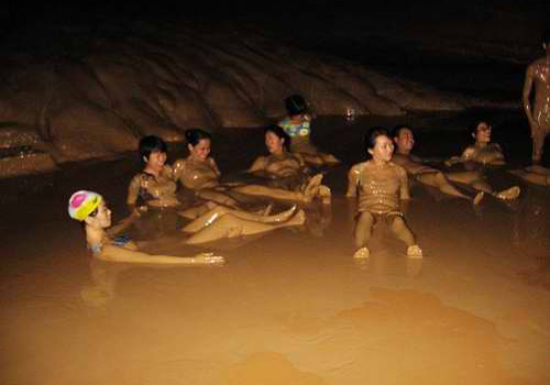 Tourists are enjoying the mud bath inside the Buddha Water Cave.