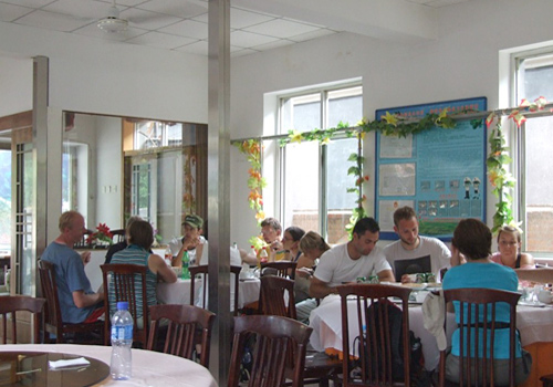 Foreign visitors are having meal at a farmhouse near the Mutianyu Great Wall.