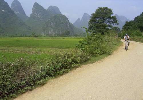 Some biking lovers are having their trip on the uneven country road in the outskirt of Yangshuo.