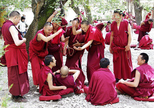 Monks of Sera Monastery are debating Buddhist sutra happily.