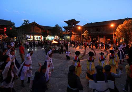 Tourists are dancing with local ethnic minotiry of Shuhe Ancient Town around the bonfire.