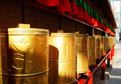 Walk around prayer wheels clockwise in Tibetan areas.